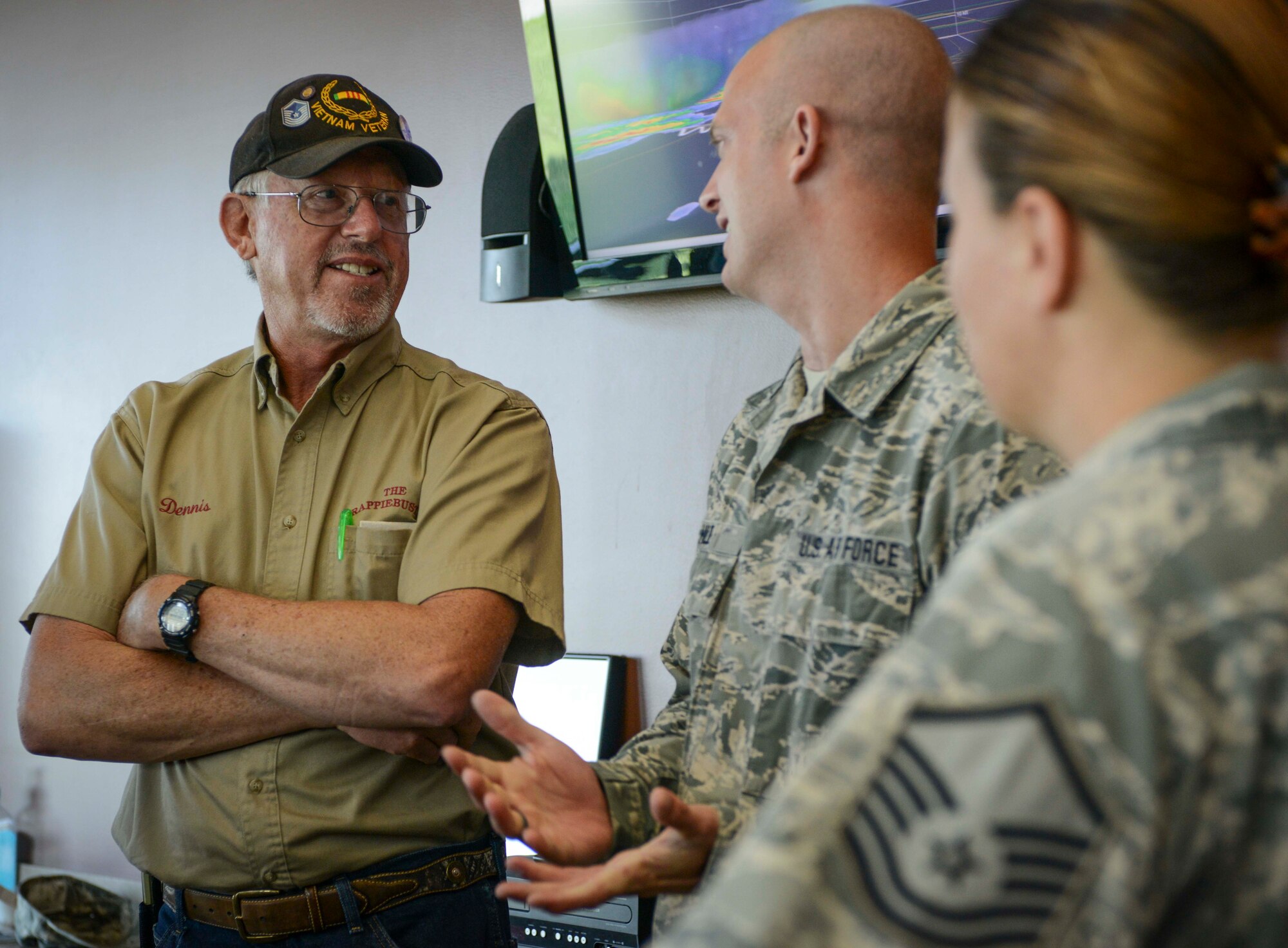 Retired Senior Master Sgt. Dennis Miller discusses weather radar with Senior Airman Scott Hilde, 5th Operations Squadron weather forecaster, on Minot Air Force Base, N.D., Aug. 8, 2014. Hilde gave Miller a tour of the new weather flight facility, and discussed the advances their career field has made in weather monitoring technology and methodology over the years. (U.S. Air Force photo/Senior Airman Stephanie Morris.)