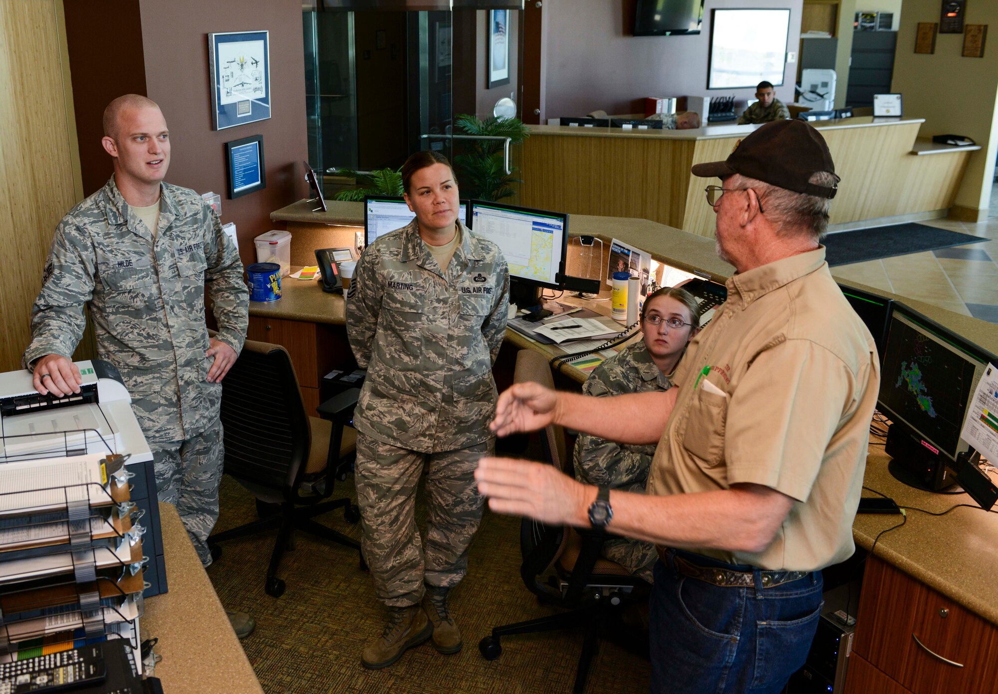 Retired Senior Master Sgt. Dennis Miller discusses weather radar with members of the 5th Operations Squadron weather flight on Minot Air Force Base, N.D., Aug. 8, 2014. During his career, Miller maintained and repaired equipment at a wide variety of locations including Thailand, Australia and Puerto Rico. (U.S. Air Force photo/Senior Airman Stephanie Morris.)