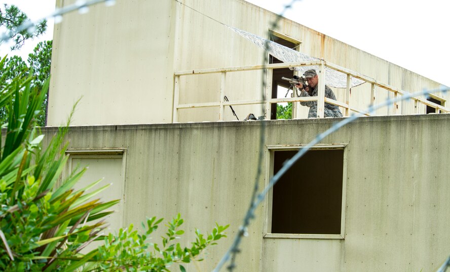 U.S. Air Force Staff Sgt. Dallas Ayers, 823d Base Defense Squadron fire team squad leader, looks through the scope of an M24 sniper weapons system during exercise Safeside Guardian at Camp Blanding, Fla., Aug. 12, 2014. The M24 is used because it has a high-powered scope. (U.S. Air Force photo by Airman 1st Class Ceaira Tinsley/Released)