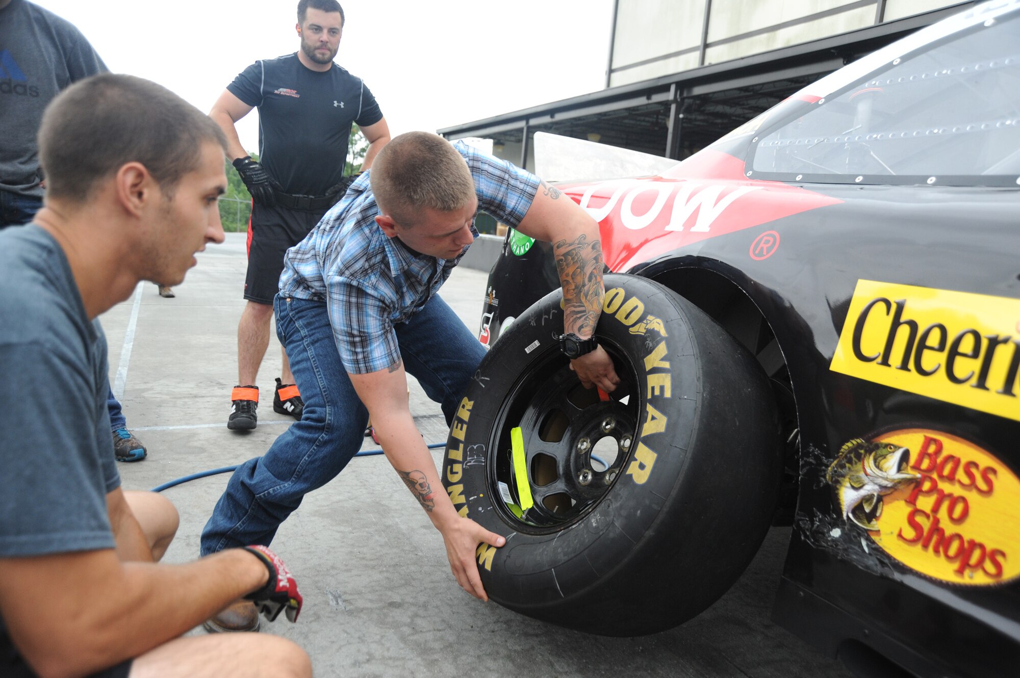 On 11 Aug. during a pit crew demonstration at the Richard Childress Racing pavilion, Private Tyler Gregory, assigned to the 95 Civil Affairs Brigade practices the technique of placing a new tire onto a race car. The tire that weighs 75LBS has to be maneuvered in a confined space among other pit crew members (U.S. Air Force photo Master Sgt. Kevin Brody).