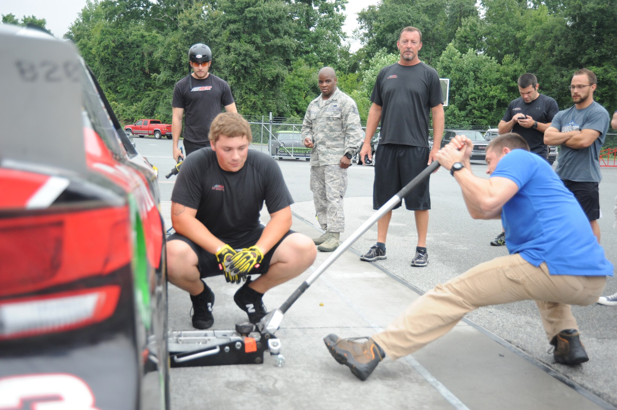 Staff Sgt. Richard Golden, assigned to the 95 Civil Affairs Brigade, Ft Bragg manipulates a floor jack during a pit crew demonstration at the Richard Childress Racing pavilion, 11Aug. RCR pit crew member coaches Golden on the proper technique to swiftly accomplish the task. After a few attempts Golden realizes that it is body mechanics and positioning not sheer strength that is needed to accomplish the task (U.S. Air Force photo Master Sgt. Kevin Brody).