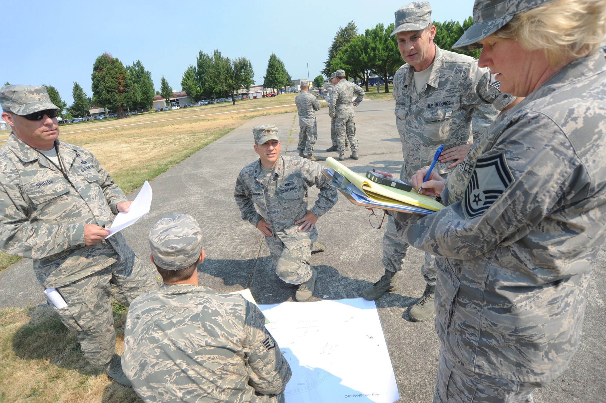 Senior Master Sgt. Linda Baugher, far right, a Wing Inspection Team member takes notes after receiving feedback from the 142nd Fighter Wing Civil Engineer Squadron has evacuated a building during an exercise conducted by the Wing Inspection Team, Aug. 2, 2014, Portland Air National Guard Base, Ore. (U.S. Air National Guard photo by Tech. Sgt. John Hughel, 142nd Fighter Wing Public Affairs/Released)

