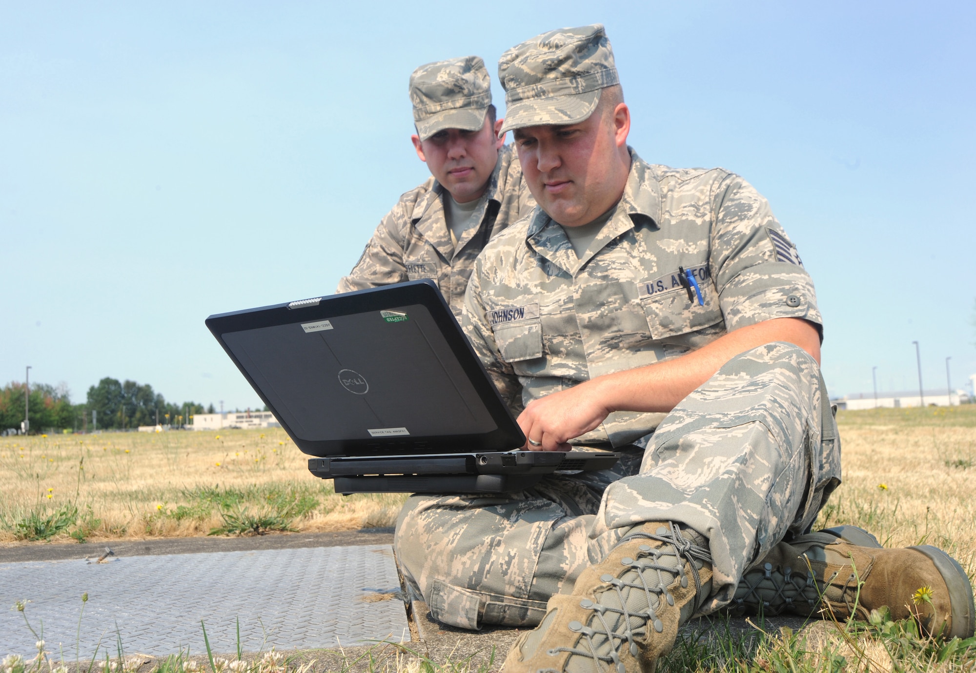 Oregon Air National Guardsmen Tech. Sgt. Matthew Shifflette, left, and Tech. Sgt. Mark (Gus) Johnson, right, use a laptop computer to continue their work after a building evacuation drill during an exercise conducted by the Wing Inspection Team, Aug. 2, 2014. Both Shifflette and Johnson are maintenance specialist assigned to the 142nd Fighter Wing Commutations Flight. (U.S. Air National Guard photo by Tech. Sgt. John Hughel, 142nd Fighter Wing Public Affairs/Released)

