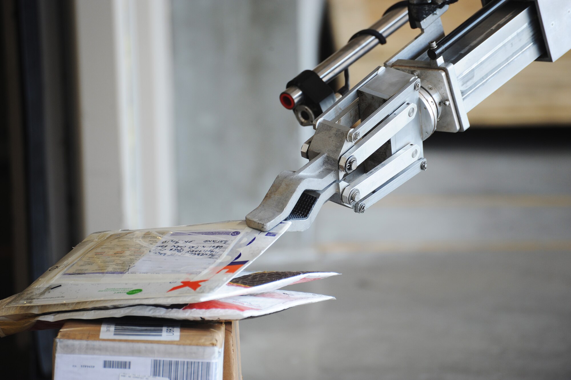 A robot operated remotely by an Explosive Ordinance Disposal member picks up a suspicious package during a Wing Inspection Team exercise, Aug. 1, 2014, Portland Air National Guard Base, Ore.  (U.S. Air National Guard photo by Tech. Sgt. John Hughel, 142nd Fighter Wing Public Affairs/Released)

