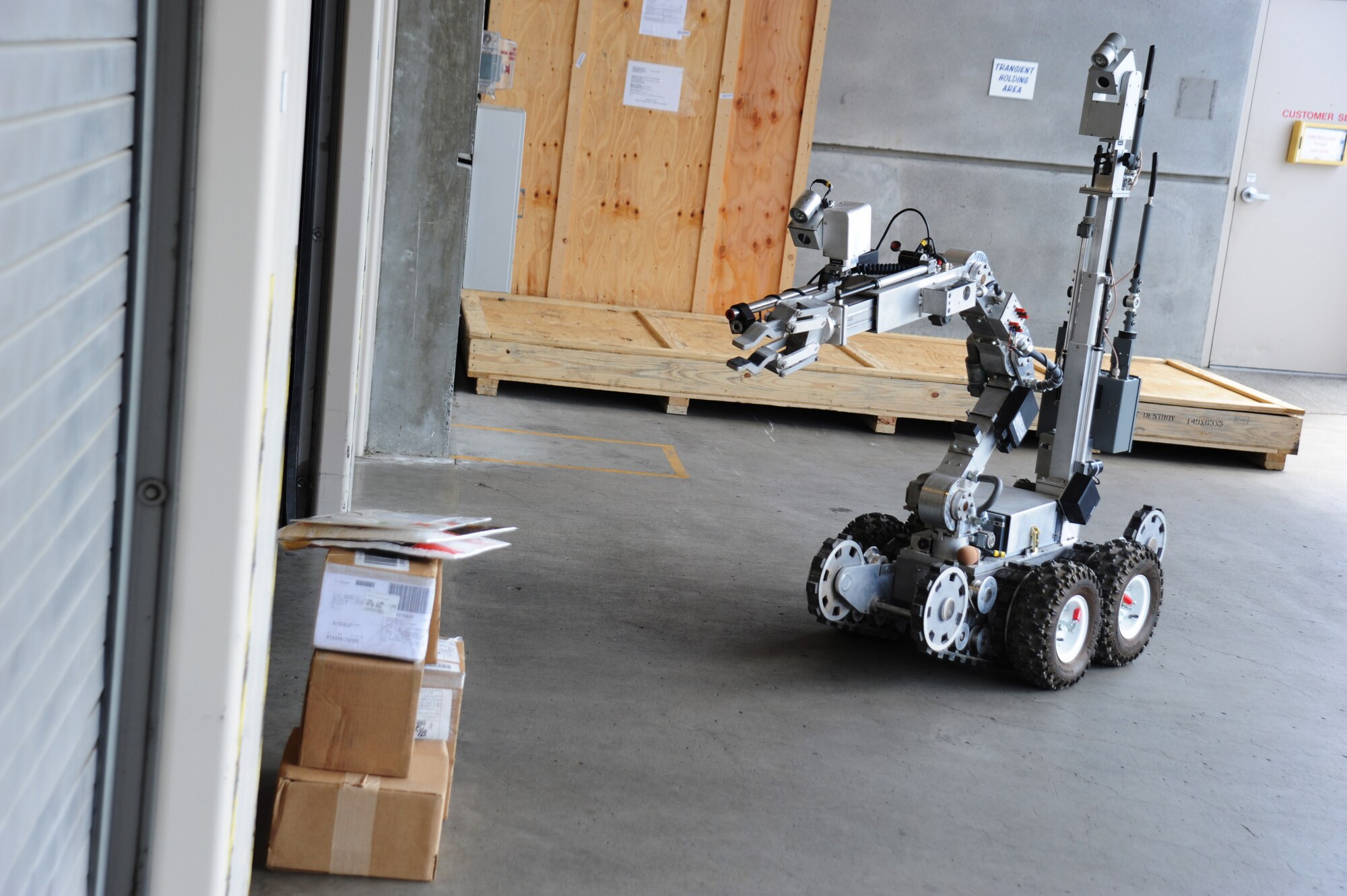 A robot operated remotely by an Explosive Ordinance Disposal member is moved into position to retrieve a suspicious package during a Wing Inspection Team exercise, Aug. 1, 2014, Portland Air National Guard Base, Ore.  (U.S. Air National Guard photo by Tech. Sgt. John Hughel, 142nd Fighter Wing Public Affairs/Released)