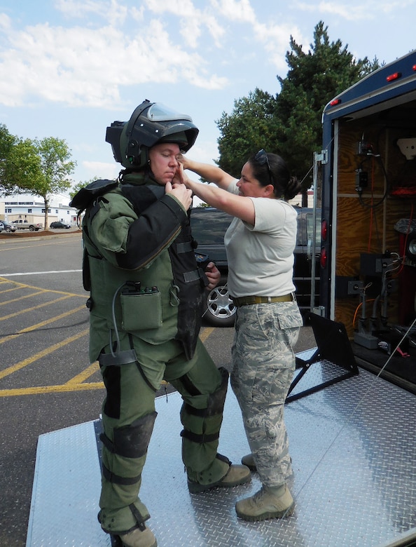 Explosive Ordinance Disposal Specialist Tech. Sgt. Jason Ganner, left, has help with his EOD 9 suit from Staff Sgt. Rachel Fleming, right, during a Wing Inspection Team exercise, Aug. 1, 2014 at the Portland Air National Guard Base, Ore. Both members are assigned to the 142nd Fighter Wing Civil Engineer Squadron. (U.S. Air National Guard photo by Lt. Col. Frank Page, courtesy 142nd Fighter Wing Inspection Team/Released)