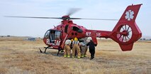 Beale firefighters load a simulated victim onto a helicopter transport during an emergency training exercise at Beale Air Force Base, Calif., Aug. 8, 2014. The exercise provided the opportunity for Beale’s emergency services personnel to gain proficiency loading patients onto medical helicopters. (U.S. Air Force photo by Airman 1st Class Ramon A. Adelan/Released)
