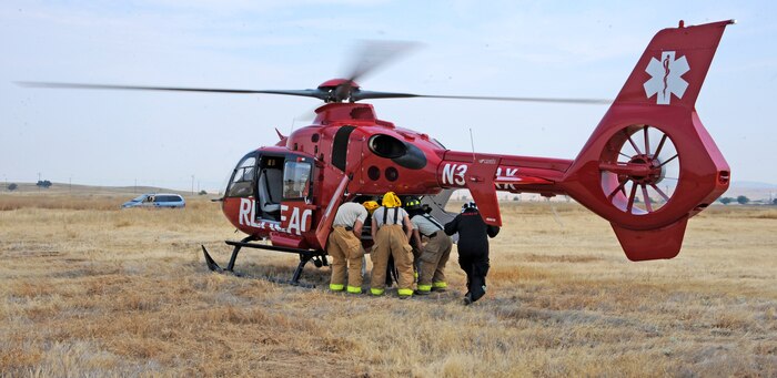 Beale firefighters load a simulated victim onto a helicopter transport during an emergency training exercise at Beale Air Force Base, Calif., Aug. 8, 2014. The exercise provided the opportunity for Beale’s emergency services personnel to gain proficiency loading patients onto medical helicopters. (U.S. Air Force photo by Airman 1st Class Ramon A. Adelan/Released)