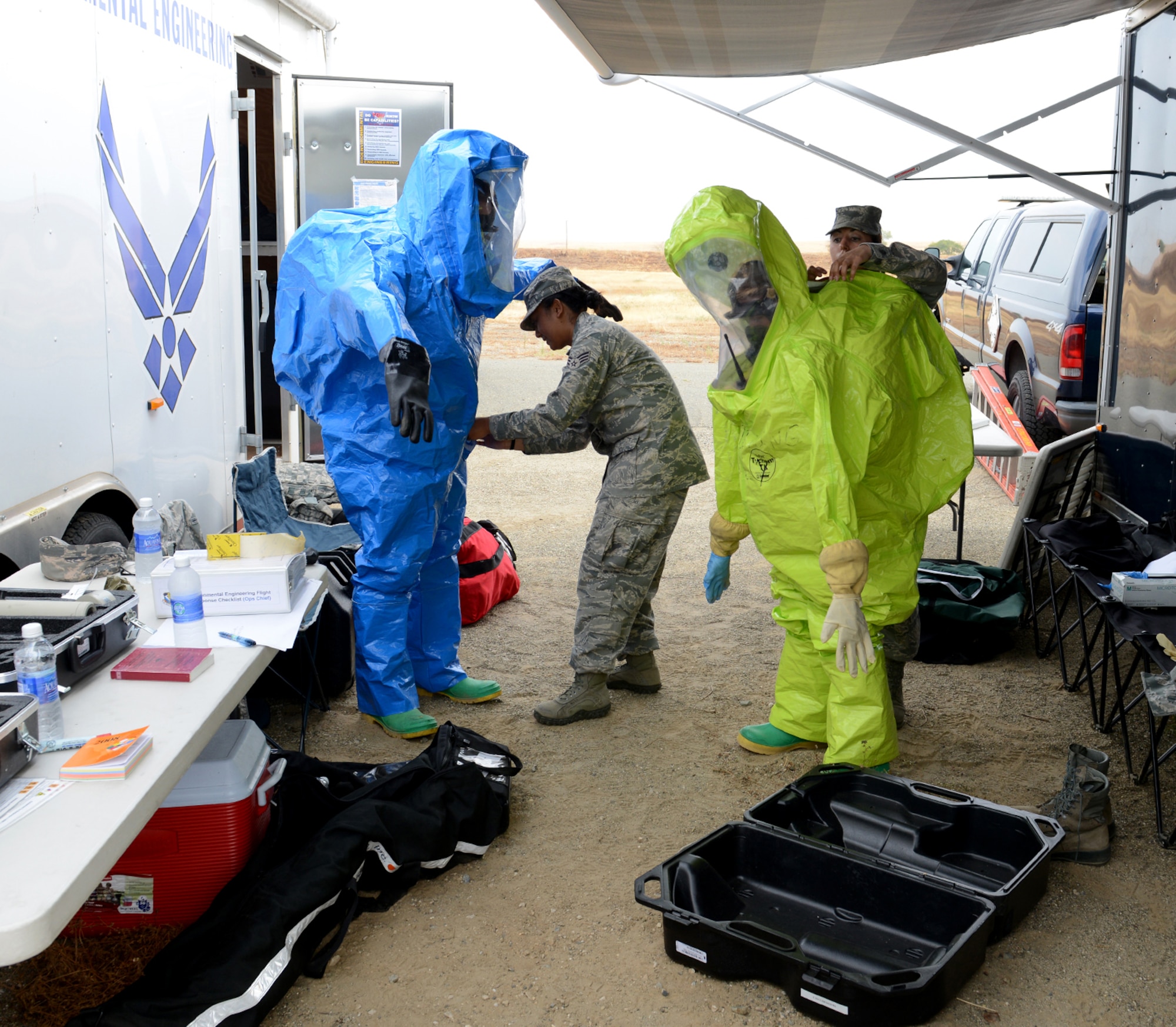 Airmen from 9th Aerospace Medicine Squadron prepare their proactive suits during an emergency services exercise at Beale Air Force Base, Calif., Aug. 8, 2014. The suits provide total containment, giving protection from all forms of chemicals: solids, liquids, and gasses/vapors. (U.S. Air Force photo by John Schwab/Released)