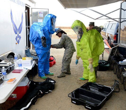 Airmen from 9th Aerospace Medicine Squadron prepare their proactive suits during an emergency services exercise at Beale Air Force Base, Calif., Aug. 8, 2014. The suits provide total containment, giving protection from all forms of chemicals: solids, liquids, and gasses/vapors. (U.S. Air Force photo by John Schwab/Released)