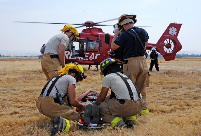Beale firefighters prepare to move a simulated victim to a helicopter transport during an emergency training exercise at Beale Air Force Base, Calif., Aug. 8, 2014. The exercise provided the opportunity for Beale’s emergency services personnel to gain proficiency loading patients onto medical helicopters. (U.S. Air Force photo by Airman 1st Class Ramon A. Adelan/Released)