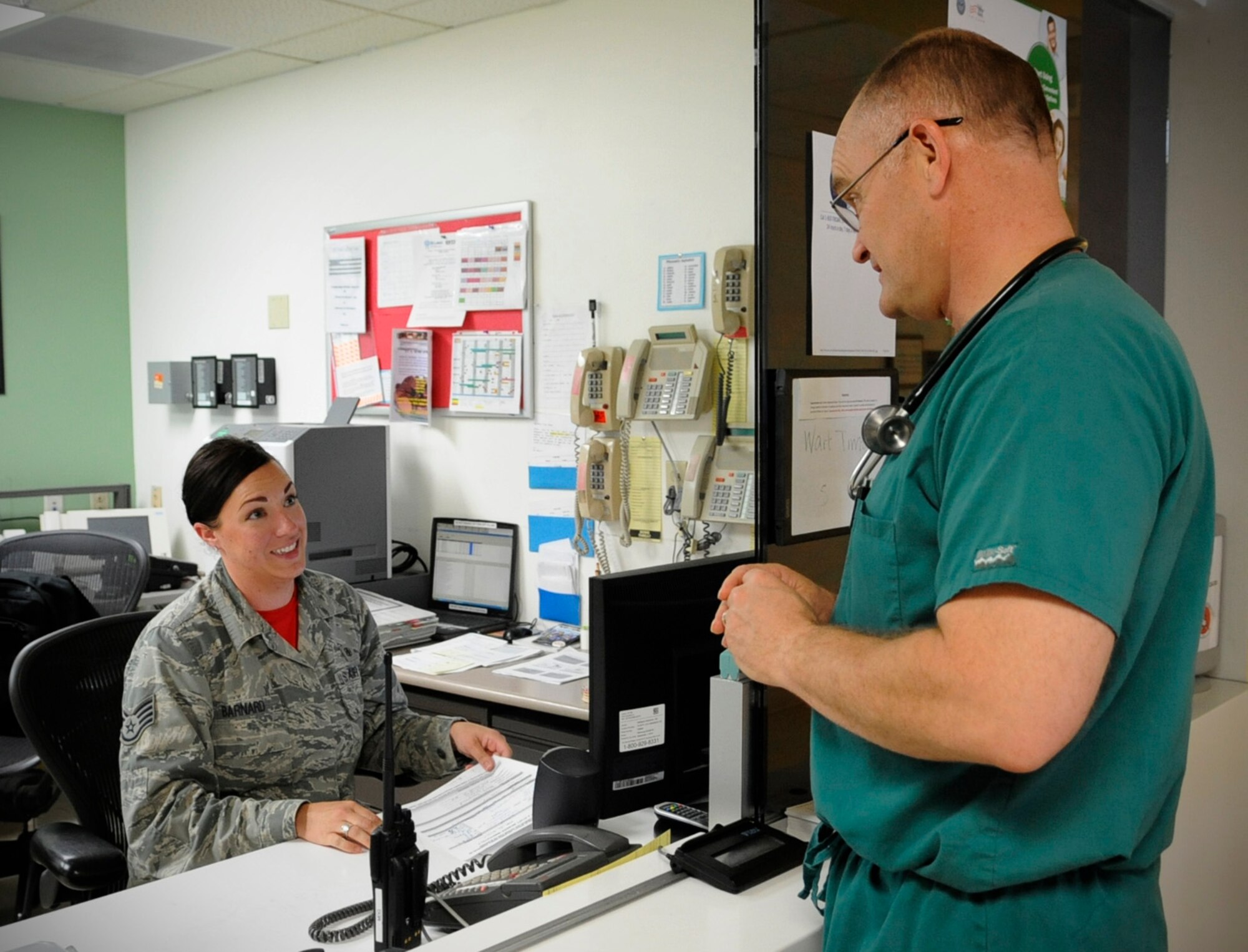 Staff Sgt. April Barnard, 366th Medical Group Urgent Care Center medical administration, consults with Col. Brandon Isaacs, 124th Medical Group commander, Aug. 1, 2014, at Mountain Home Air Force Base, Idaho. Providing outstanding medical care around the clock, each member of the UCC team is dedicated to providing the best care possible. (U.S. Air Force photo by Senior Airman Caitlin Guinazu/RELEASED)


