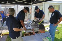 Volunteers from the 13th Reconnaissance Squadron prepare food for participants of the the World's Largest Golf Outing, benefiting the Wounded Warrior Project, Aug. 11, 2014, at Lincoln Hills Golf Club in Lincoln, Calif. The World's Largest Golf Outing is an annual event spanning across 26 states at more than 120 courses simultaneously. (U.S. Air Force photo by Airman 1st Class Ramon A. Adelan/Released)