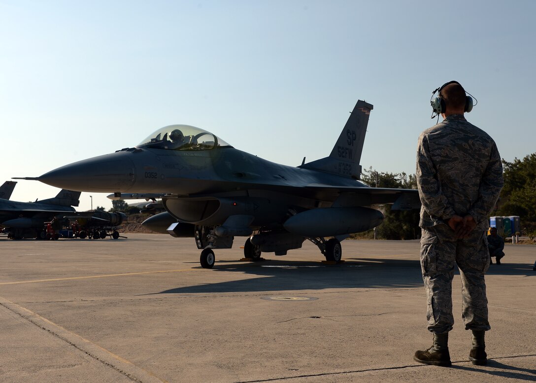 U.S. Air Force Senior Airman Alan Nelson, 52nd Aircraft Maintenance Squadron's 480th Aircraft Maintenance Unit  and native of Pensacola, Fla., watches the F-16 Fighting Falcon fighter aircraft of U.S. Air Force Col. Pete Bilodeau, 52nd Fighter Wing commander, during a bilateral training event in Souda Bay, Greece, Aug. 12, 2014. Bilodeau flew out to Souda Bay from Spangdahlem Air Base, Germany, to meet with the Hellenic air force's 115th Combat Wing commander and participate in one of the initial days of the training. (U.S. Air Force photo by Staff Sgt. Daryl Knee/Released)