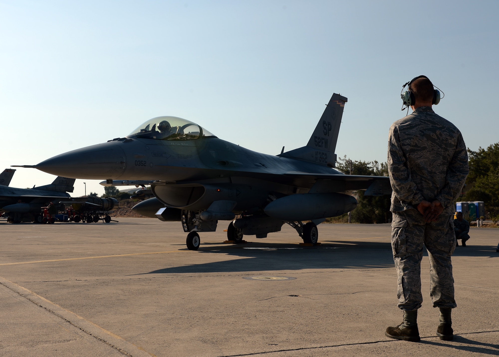 U.S. Air Force Senior Airman Alan Nelson, 52nd Aircraft Maintenance Squadron's 480th Aircraft Maintenance Unit  and native of Pensacola, Fla., watches the F-16 Fighting Falcon fighter aircraft of U.S. Air Force Col. Pete Bilodeau, 52nd Fighter Wing commander, during a bilateral training event in Souda Bay, Greece, Aug. 12, 2014. Bilodeau flew out to Souda Bay from Spangdahlem Air Base, Germany, to meet with the Hellenic air force's 115th Combat Wing commander and participate in one of the initial days of the training. (U.S. Air Force photo by Staff Sgt. Daryl Knee/Released)