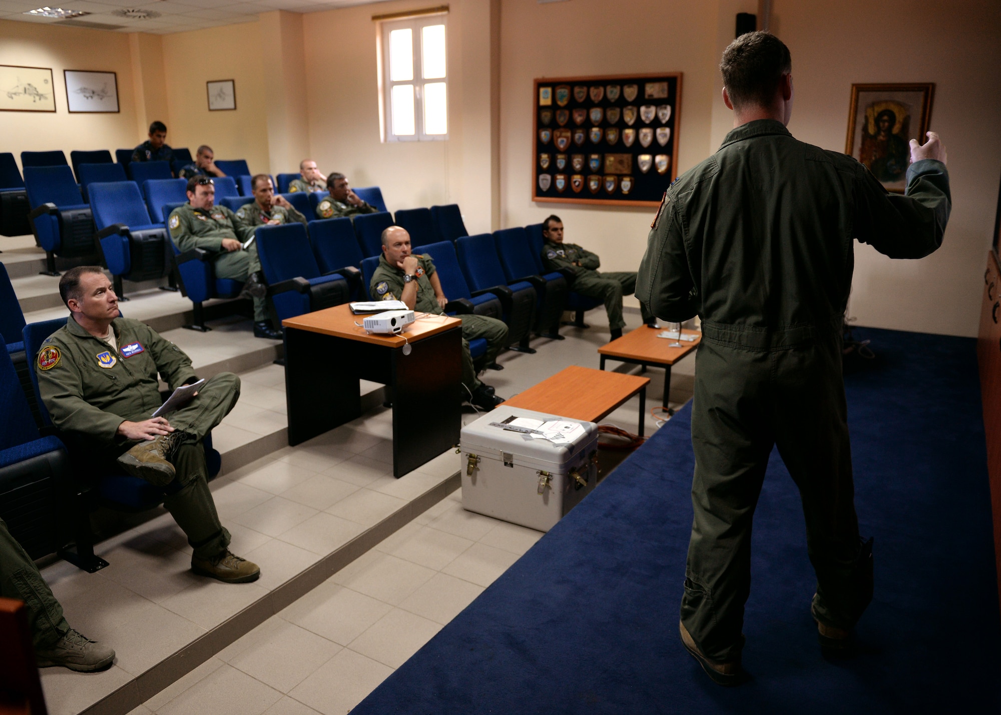 A pilot from the 480th Fighter Squadron from Spangdahlem Air Base, Germany, briefs a group of U.S. and Greek pilots Aug. 12, 2014, before a flying mission at the bilateral training event in Souda Bay, Greece. The pilots attend the mass briefing to clarify the objectives of the day's training and to receive the latest information on the weather and threat intelligence. (U.S. Air Force photo by Staff Sgt. Daryl Knee/Released)