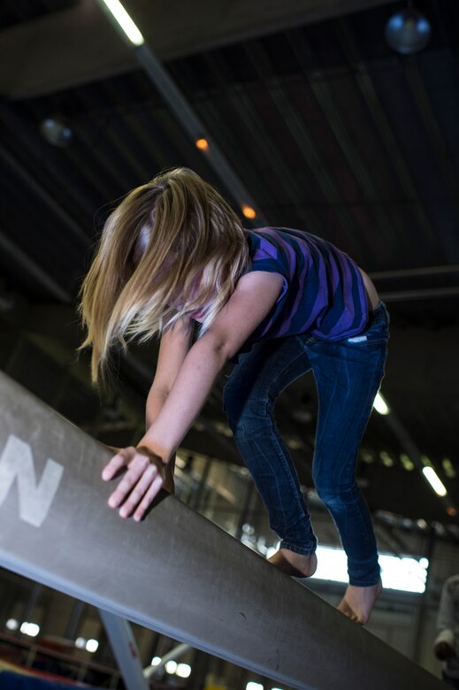 Sophie Dickson, daughter of Shanna Dickson, performs a bear crawl on a balance beam during the Exceptional Family Member Program camp at Bitburg Annex, Germany, Aug. 12, 2014. More than 20 children participated in the two-week long program. (U.S. Air Force photo by Staff Sgt. Christopher Ruano/Released)