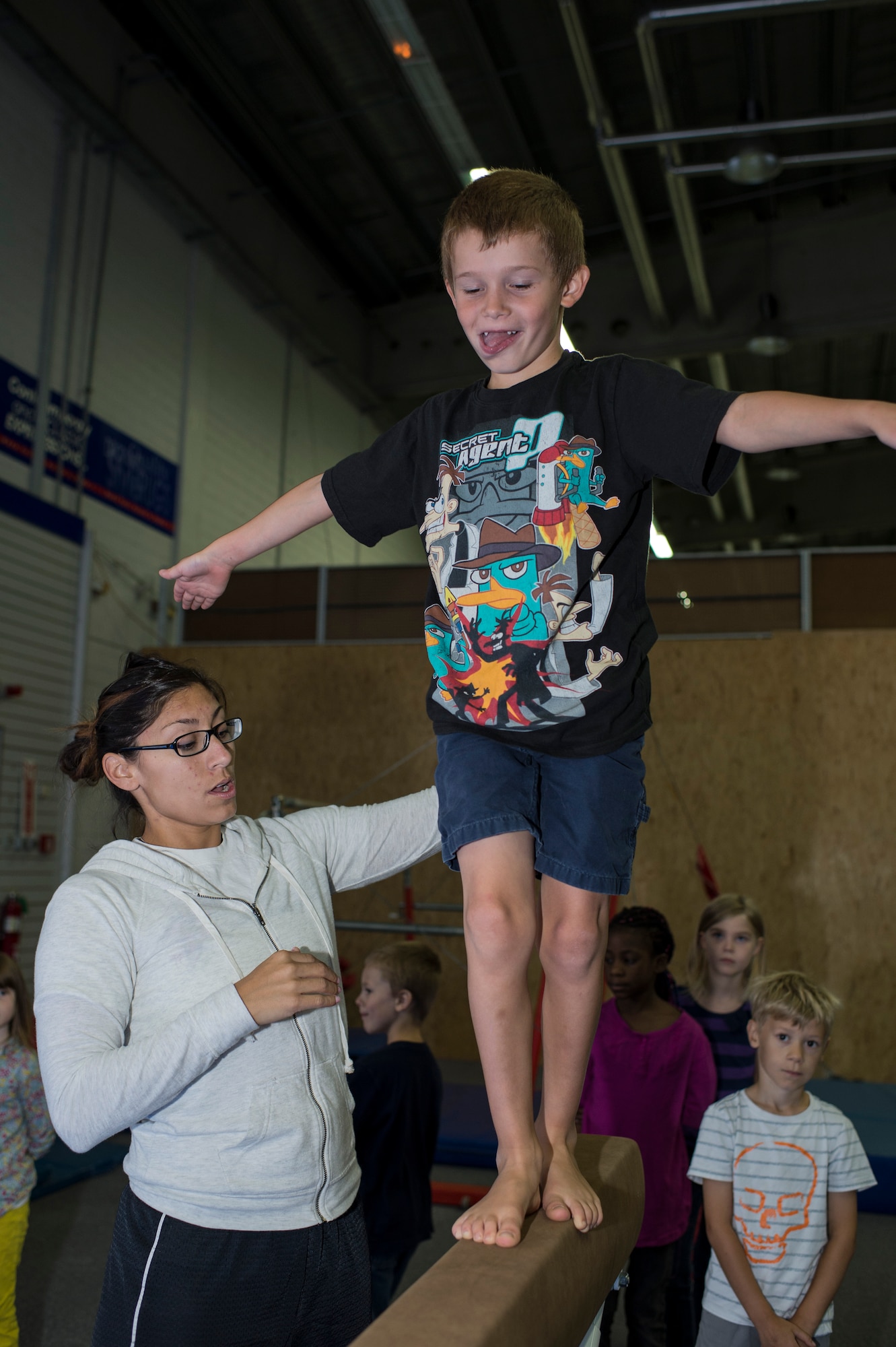 Cat Schnoes, gymnastics coach, wife of U.S. Air Force Tech. Sgt. Karl Schnoes, 52nd Civil Engineer Squadron firefighter, instructs Ethan Fisher, son of Shelli Tiff, how to walk on a balance beam during the Exceptional Family Member Program camp at Bitburg Annex, Germany, Aug. 12, 2014. The EFMP works with military families with special needs children to address and accommodate their specific needs at their installation. (U.S. Air Force photo by Staff Sgt. Christopher Ruano/Released)