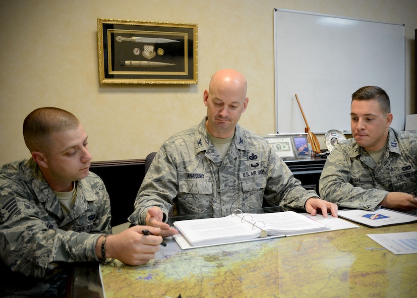 Col. Mark Anarumo, 39th Air Base Wing vice commander, discusses daily operations with Staff Sgt. Robert Wayland, 39th ABW command chief executive assistant (left),  and Capt. Thomas Uhl (right), 39th ABW executive officer, Aug. 12, 2014, Incirlik Air Base, Turkey. As vice commander, he is responsible for approximately 5,000 U.S. military, civilian and contractor personnel and the combat readiness of U.S. Air Force units at Incirlik and two geographically-separated units in Turkey. (U.S. Air Force photo by Staff Sgt. Veronica Pierce) 