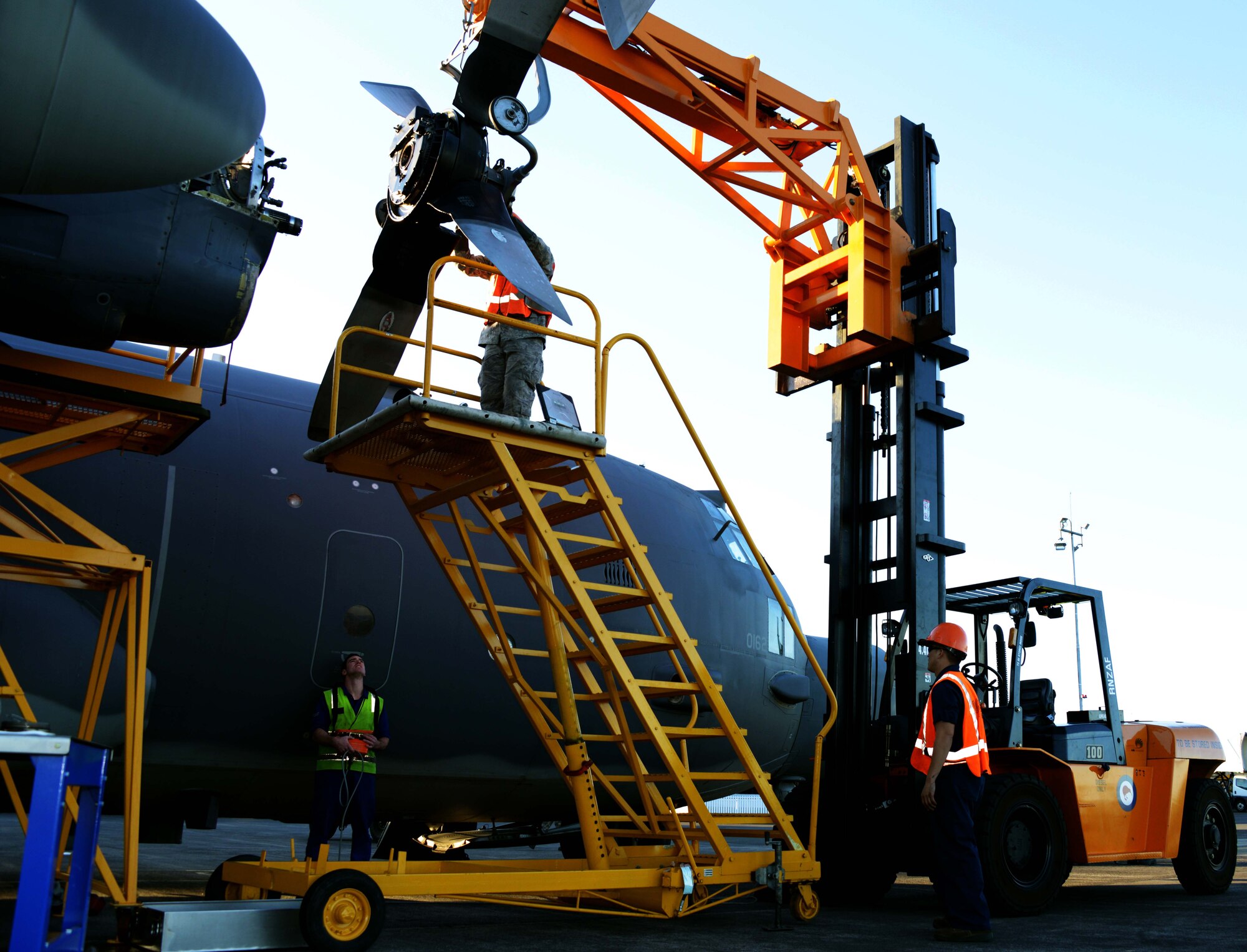 Maintainers from the 353rd Special Operations Maintenance Squadron work with members from the New Zealand Defense Force to remove a propeller for repair July 28, 2014 in Whenuapai, New Zealand.  Members from the 353rd Special Operations Group participated in Exercise Balance Net July 17 through July 31 in Whenuapai, New Zealand. During the exercise, members from both the New Zealand Defense Force and U.S. Air Forces worked together to conduct personnel and equipment air drops while exchanging new techniques. This was the first time in almost three decades the group has deployed to New Zealand.  (U.S. Air Force photo by Tech. Sgt. Kristine Dreyer)