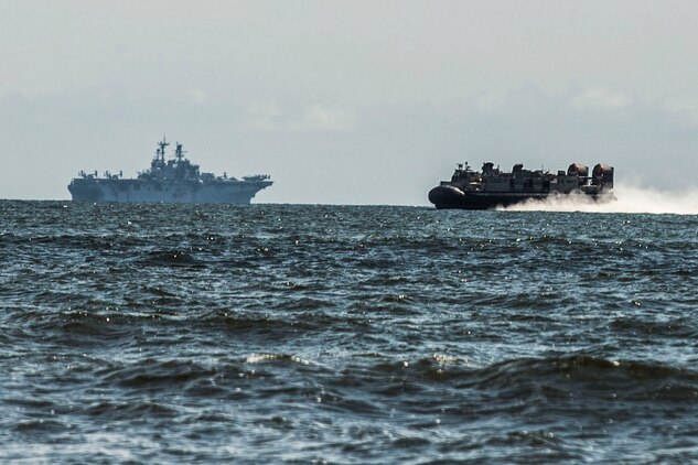 A Landing Craft Air Cushion, or LCAC, from Assault Craft Unit 4 conducting operations from the USS Iwo Jima, approaches Onslow Beach, N.C., during a tactical offload of 24th Marine Expeditionary Unit personnel and equipment, August 12, 2014. The offload was part of Amphibious Squadron/Marine Expeditionary Unit Integration, the second major exercise for the 24th MEU. The USS Iwo Jima is part of the Iwo Jima Amphibious Ready Group. (U.S. Marine Corps photo by Cpl. Mary M. Carmona)