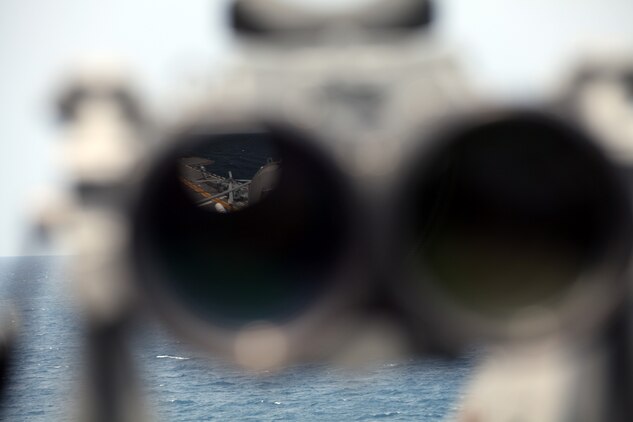 The CH-53E Super Stallion and the port-side elevator on the flight deck of the USS Iwo Jima as seen through a pair of the ship’s binoculars, August 8, 2014, as the ship floats off the coast of North Carolina. The Super Stallion is from Marine Medium Tiltrotor Squadron 365 (Reinforced), 24th Marine Expeditionary Unit. The 24th MEU is taking part in Amphibious Squadron/ Marine Expeditionary Unit Integration, or PMINT, the MEU’s second major pre-deployment training exercise. PMINT is designed to bring Marines and Sailors from the 24th MEU and Amphibious Squadron 8 together for the first time aboard the ships of the Iwo Jima Amphibious Ready Group. (U.S. Marine Corps Photo by Lance Cpl. Joey Mendez)