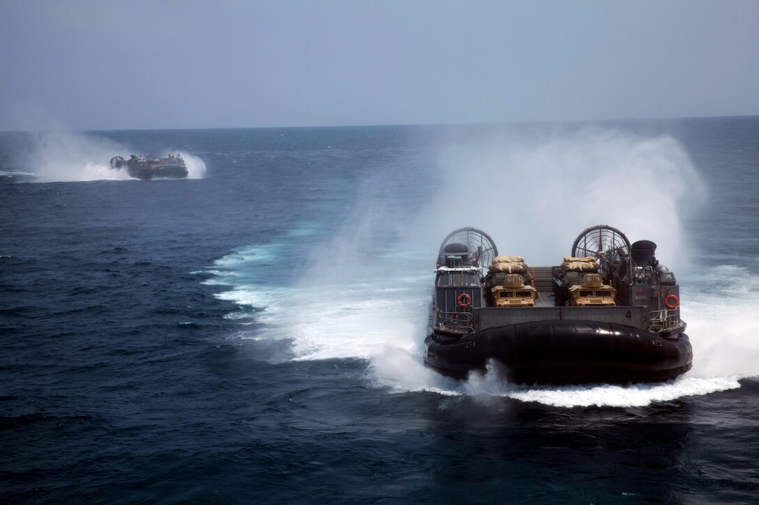 Two Landing Craft, Air-Cushion, or LCACs, approach the USS Iwo Jima off the coast of North Carolina, August 8, 2014. The LCACs carried 24th Marine Expeditionary Unit vehicles and equipment from shore to ship during Amphibious Squadron/Marine Expeditionary Unit Integration, or PMINT, the 24th MEU’s second major pre-deployment training exercise. PMINT is designed to bring Marines and Sailors from the 24th MEU and Amphibious Squadron 8 together for the first time aboard the ships of the Iwo Jima Amphibious Ready Group. (U.S. Marine Corps Photo by Cpl. Todd F. Michalek) 
