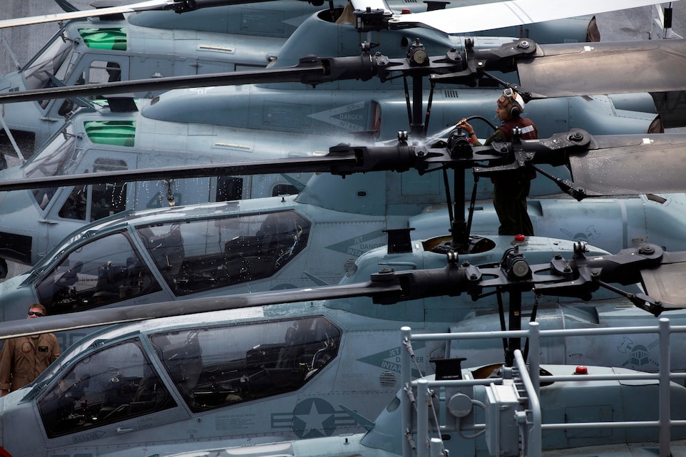 A Marine with Marine Medium Tiltrotor Squadron 365 (Reinforced), 24th Marine Expeditionary Unit rinses an AH-1W Cobra on the flight deck of the USS Iwo Jima, August 8, 2014. The 24th MEU is taking part in Amphibious Squadron/ Marine Expeditionary Unit Integration, or PMINT, the 24th MEU’s second major pre-deployment training exercise. PMINT is designed to bring Marines and Sailors from the 24th MEU and Amphibious Squadron 8 together for the first time aboard the ships of the Iwo Jima Amphibious Ready Group. (U.S. Marine Corps Photo by Cpl. Todd F. Michalek)