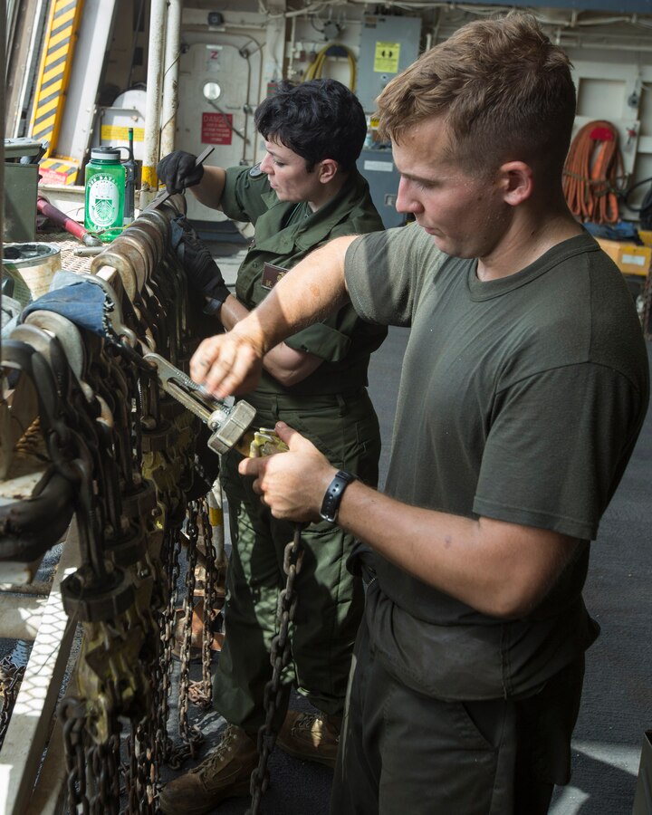 U.S. 5TH FLEET AREA OF RESPONSIBILITY (Aug. 2, 2014) U.S. Marine Corps Cpl. Devon Cole, left, Marine Medium Tiltrotor Squadron (VMM) 263 (Reinforced), 22nd Marine Expeditionary Unit (MEU), expediter and native of San Diego, Calif., and Cpl. Logan Mange, VMM-263 (Rein.) CH-53E Super Stallion mechanic and native of Bolton, Ohio, remove rust from flight deck chains aboard the amphibious transport dock ship USS the Mesa Verde (LPD 19). The 22nd MEU is deployed with the Bataan Amphibious Ready Group as a theater reserve and crisis response force throughout U.S. Central Command and the U.S. 5th Fleet area of responsibility. (U.S. Marine Corps photo by Cpl. Manuel A. Estrada/Released)
