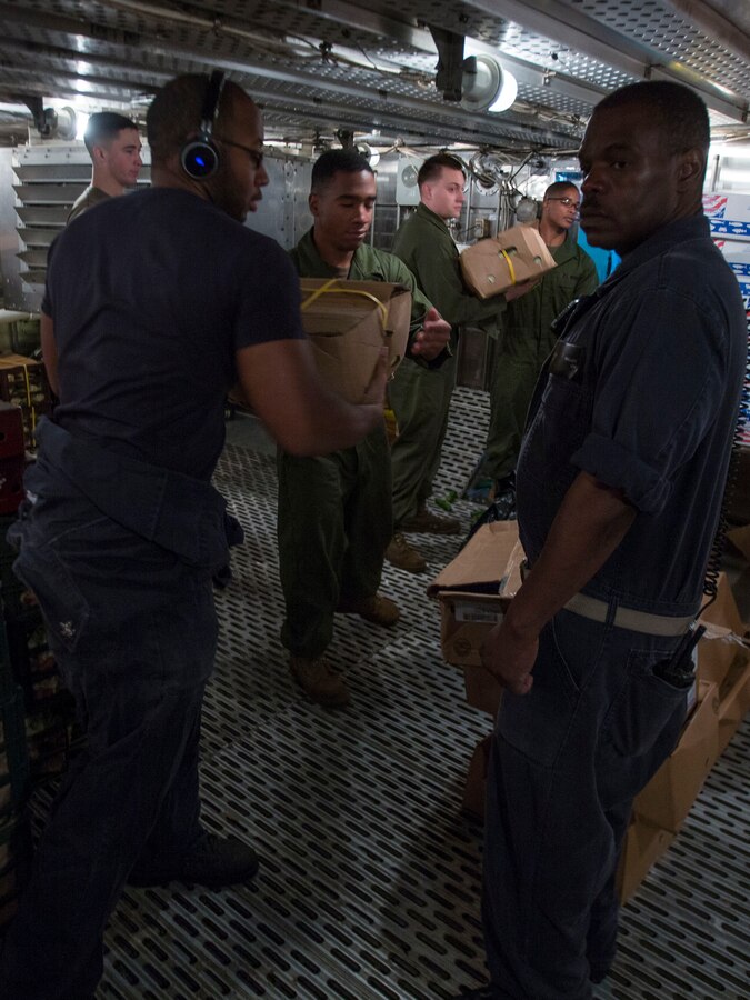 U.S. 5TH FLEET AREA OF RESPONSIBILITY (July 23, 2014) U.S. Marines with the 22nd Marine Expeditionary Unit (MEU) and U.S. Navy Sailors aboard the amphibious transport dock ship USS Mesa Verde (LPD 19) put cargo into cold storage during a replenishment at sea. The 22nd MEU is deployed with the Bataan Amphibious Ready Group as a theater reserve and crisis response force throughout U.S. Central Command and the U.S. 5th Fleet area of responsibility. (U.S. Marine Corps photo by Cpl. Manuel A. Estrada/Released)