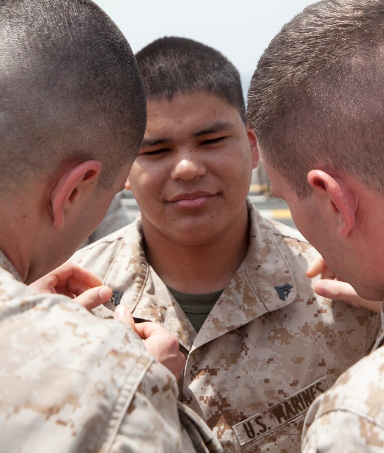 U.S. 5TH FLEET AREA OF RESPONSIBILITY (Aug. 1, 2014) U.S. Marines with Battalion Landing Team (BLT) 1st Battalion, 6th Marine Regiment, 22nd Marine Expeditionary Unit (MEU), promote Cpl. Adrian Moreno, BLT 1/6 intelligence analyst and native of Tehachapi, Calif., to his current rank aboard the amphibious transport dock ship USS Mesa Verde (LPD 19). The 22nd MEU is deployed with the Bataan Amphibious Ready Group as a theater reserve and crisis response force throughout U.S. Central Command and the U.S. 5th Fleet area of responsibility. (U.S. Marine Corps photo by Staff Sgt. Lukas Atwell /Released)