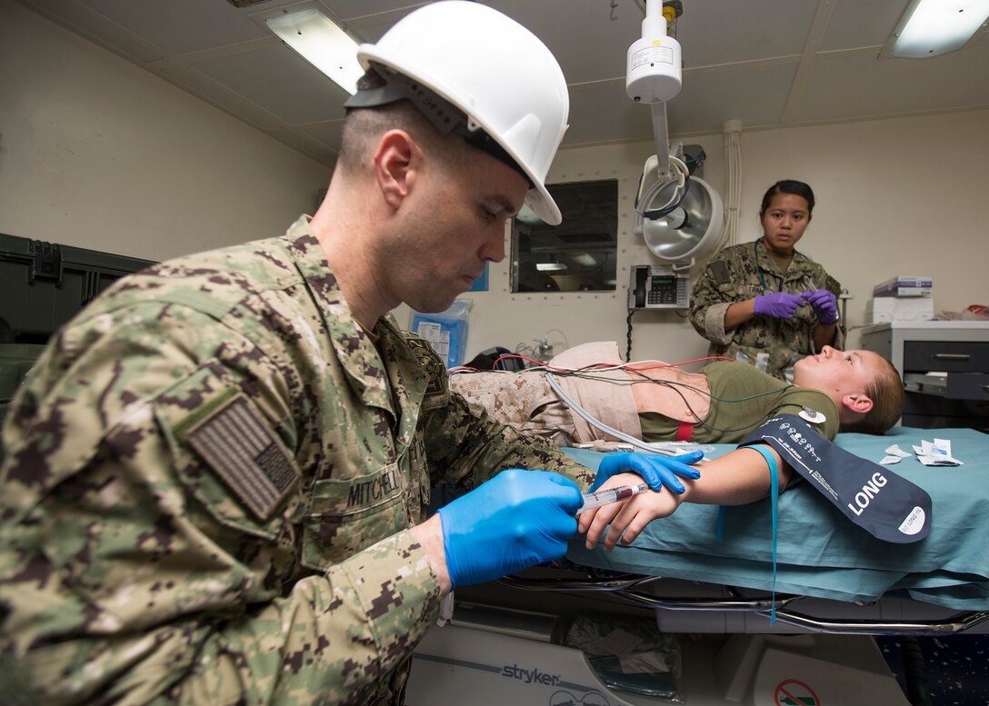 U.S. 5TH FLEET AREA OF RESPONSIBILITY (Aug. 7, 2014) U.S. Navy Lt. Cmdr. John Mitchell, an anesthesiologist with Expeditionary Resuscitative Surgical System (ERSS) Team 12 and native of Okemos, Mich., starts an IV on a simulated casualty during a mass causality drill aboard the amphibious transport dock ship USS Mesa Verde (LPD 19). The 22nd MEU is deployed with the Bataan Amphibious Ready Group as a theater reserve and crisis response force throughout U.S. Central Command and the U.S. 5th Fleet area of responsibility. (U.S. Marine Corps photo by Cpl. Manuel A. Estrada/Released)