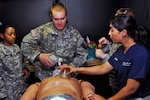 Pfc. Tyler Kinzel, a Port Jervis, N.Y., resident assigned to Medical Command, New York Army National Guard, begins bag-mask ventilating a medical mannequin after inserting an endotracheal tube through the esophagus under the direction of Dr. Anar Patel on Aug. 5, 2014.