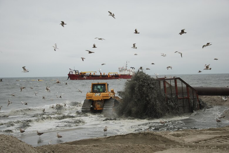 A slurry of sand and water is pumped from a nearby dredge onto Monmouth Beach, where it is moved into place by a bulldozer during the U.S. Army Corps of Engineers' ongoing beach renourishment work in Monmouth Beach, N.J., Thursday July 25, 2013. 