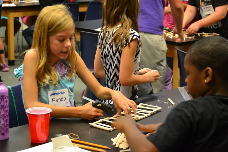 Students at the STARBASE Academy in WInchester work to build a popsicle stick bridge. Engineers from the Middle East District spoke to the students about engineering.