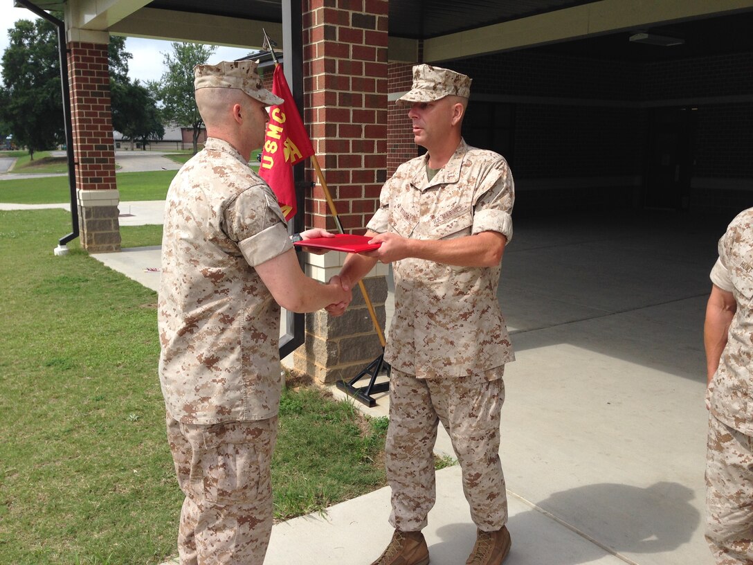 CWO4 Matthew Studer, Executive Officer of Alpha Company, Marine Corps Detachment Fort Lee, presents Sgt Justin Brown a Certificate of Commendation.  Sgt Brown was selected as the Instructor of the Quarter for Alpha Company.  (Photo provided by CWO4 Allen Ostermann, Marine Corps Detachment Public Affairs Officer/Released)
