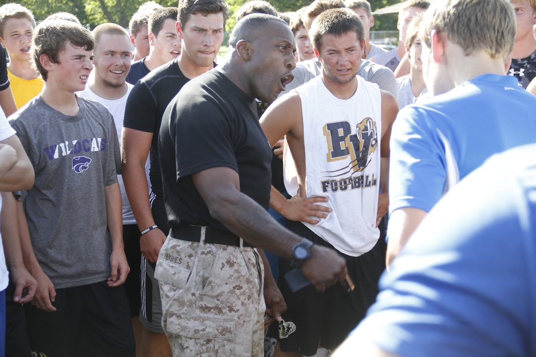 Sergeant Major Johnnie Hughes, Marine Corps Recruiting Station Kansas City sergeant major, motivates the Blue Valley High School Tigers football team before the start of the Marine Corps' Combat Fitness Test at the Lamar District Athletic Complex Aug. 14, 2014. 