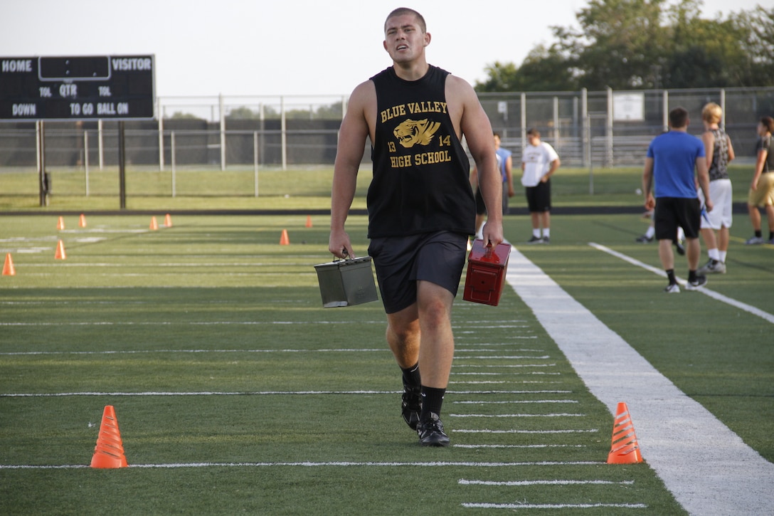 Daniel C. Carroll, a senior Blue Valley High School Tigers defensive tackle and right tackle, sprints with 30-pound ammunition cans during the Marine Corps' Combat Fitness Test at the Lamar District Athletic Complex, Aug. 14, 2014. 