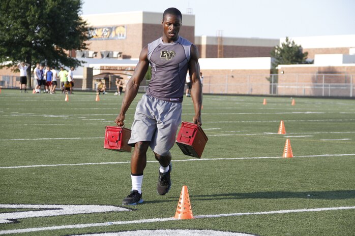 Gannon C. Cornley, a senior Blue Valley High School Tigers cornerback, running back, and wide receiver, performs cone drills while carrying two 30-pound ammunition cans during the Marine Corps' Combat Fitness Test at the Lamar District Athletic Complex Aug. 14, 2014. Marines from Recruiting Station Kansas City and Recruiting Sub-Station Olathe psuhed the players to dig deep and finish strong. The CFT consists of an 880-meter sprint, ammo-can lifts in two minutes, and a maneuver-under-fire portion.