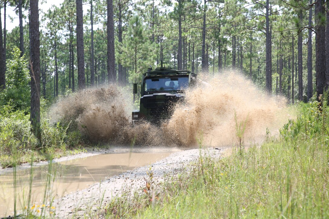 Marines with Motor Transportation Services Company, Combat Logistics Battalion 25, Combat Logistics Regiment 45, navigate through a water-fording training route at Camp Lejeune, North Carolina Aug. 13, 2014, during exercise Heavy Metal 14. For many of the Marines participating, it was their first time navigating through water in their vehicles.
