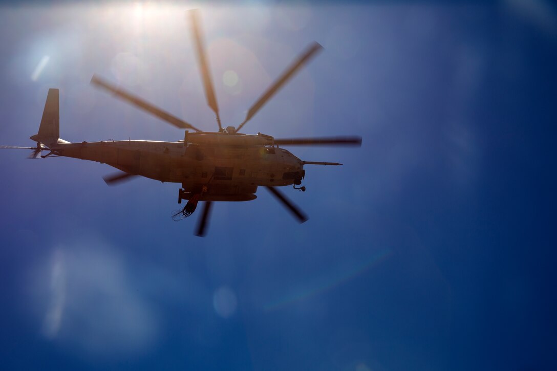 A CH-53E Super Stallion with the 3rd Marine Aircraft Wing flies overhead carrying an empty bucket to a simulated fire during the wildland firefighting exercise with the Miramar Fire Department aboard Marine Corps Air Station Miramar, Calif., Aug. 14. This is the first time the two elements combined to work together for training, and are slated to train together to prepare for any wildfires that may occur.