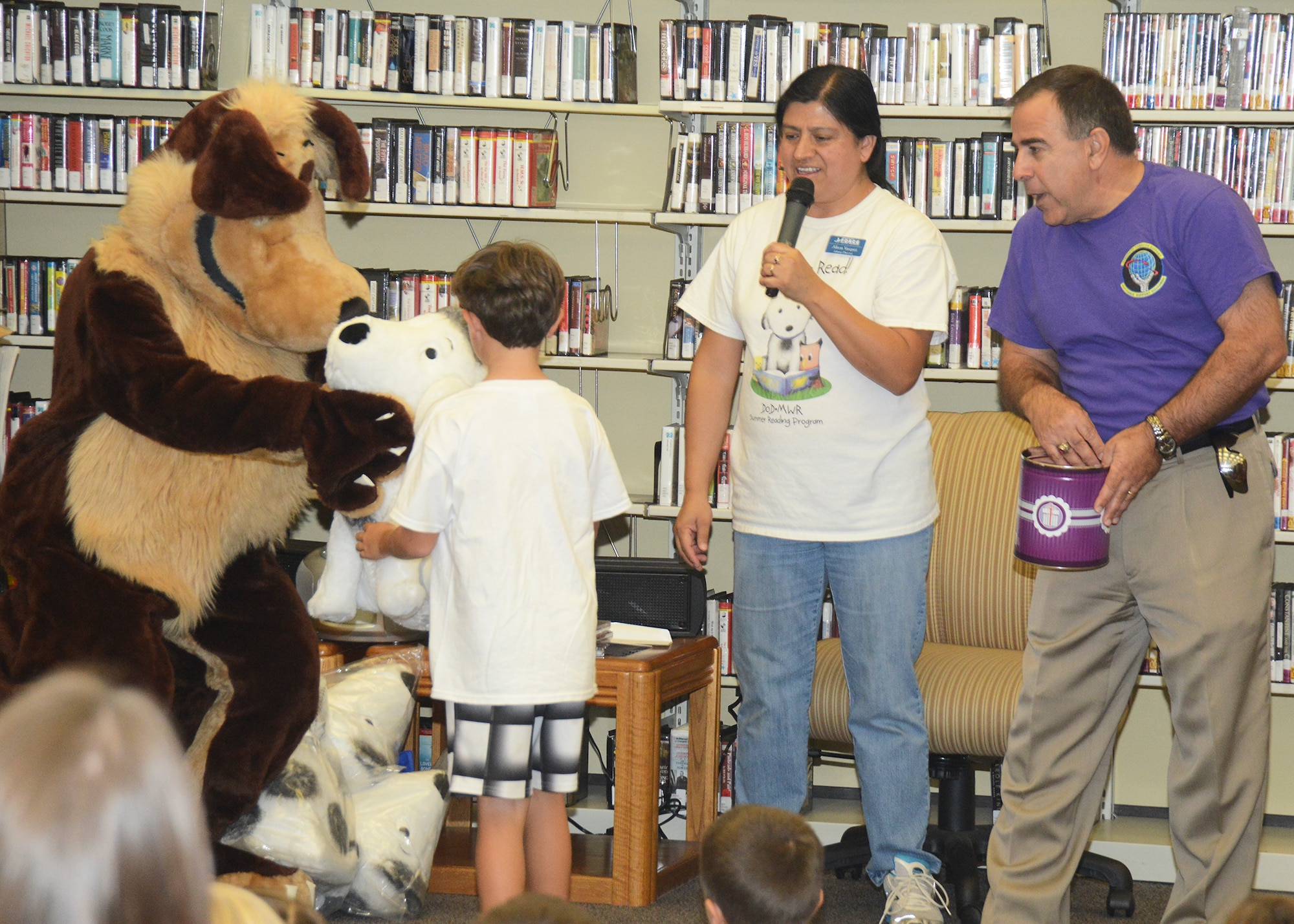 From left: Eddie the Coyote, Edwards Air Force Base mascot, presents a stuffed dog to a young raffle winner Aug. 15 during the grand finale of the Base Library's Summer Reading Program. The program was headed by library director Alison Vasquez (center). Alexander Kovras (left), 412th Force Support Squadron director, helped draw names from a can for prizes to be awarded to those children who read all 100 books assigned during the program. (U.S. Air Force photo by Kenji Thuloweit)
