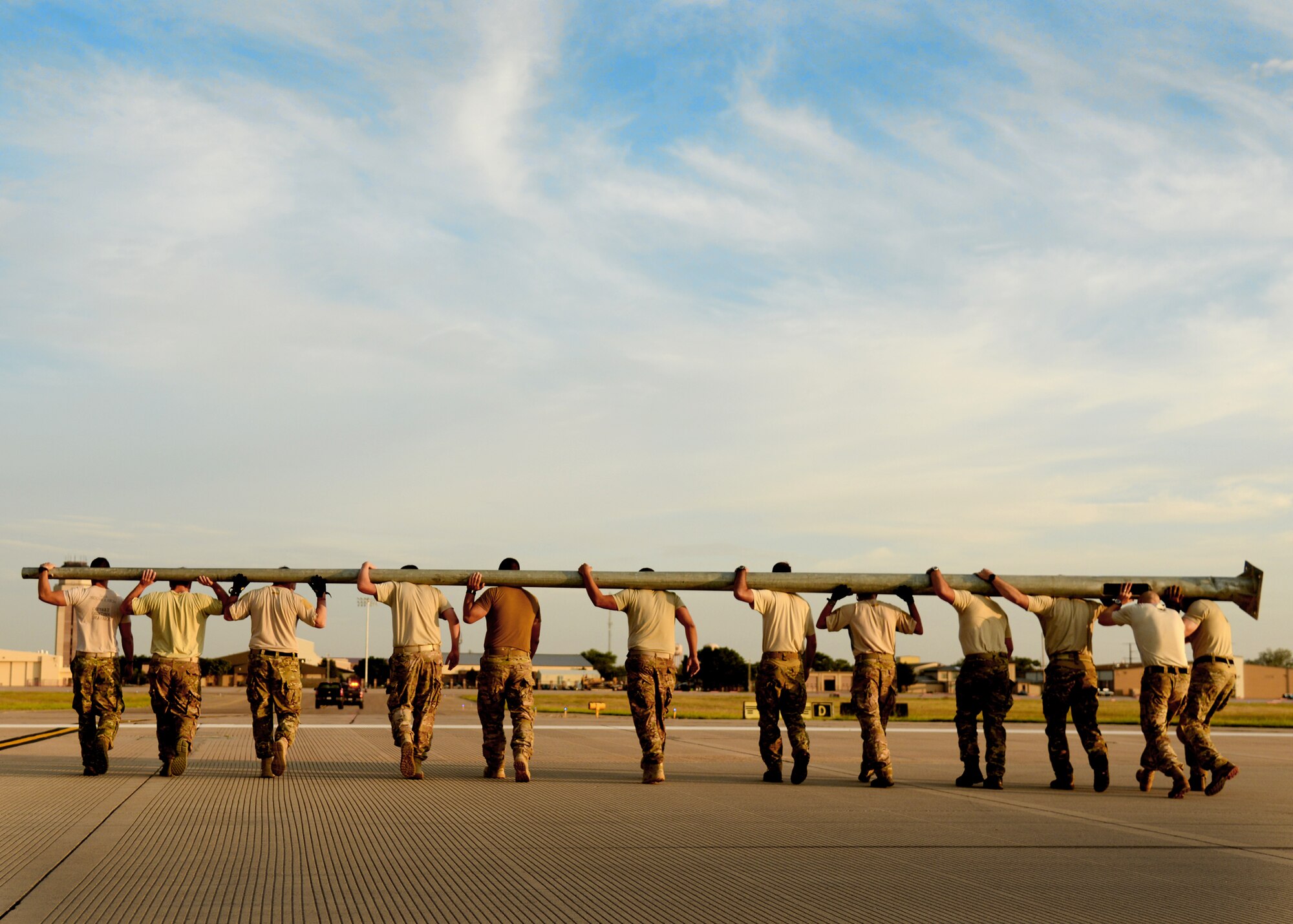 Members of the 26th Special Tactics Squadron carry a flagpole across the flightline at Cannon Air Force Base, N.M., Aug. 5, 2014. The flag pole was flown in from Afghanistan and will be erected at Cannon to honor Air Commandos who have paid the ultimate sacrifice. (U.S. Air Force Photo/Airman 1st Class Chip Slack)