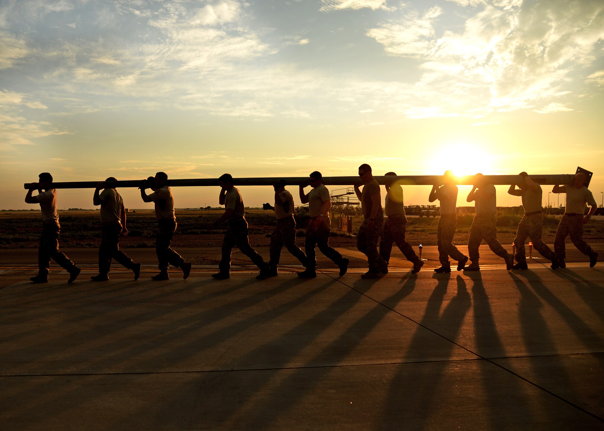 Members of the 26th Special Tactics Squadron carry a flagpole across the flightline at Cannon Air Force Base, N.M., Aug. 5, 2014. The flag pole was flown in from Afghanistan and will be erected at Cannon to honor Air Commandos who have paid the ultimate sacrifice. (U.S. Air Force Photo/Airman 1st Class Chip Slack)