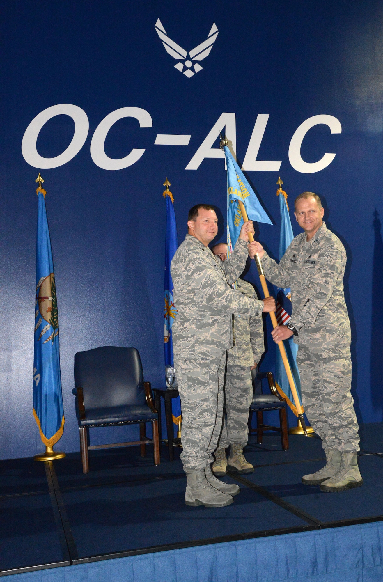 Brig. Gen. Mark K. Johnson, left, passes the guidon to Col. Kenton Ruthardt, making him the new commander of DLA Aviation at Oklahoma City. Colonel Ruthardt assumed command during an Aug. 6 ceremony at Hollywood and Vine in Bldg. 3001. General Johnson is the DLA Aviation commander, from Richmond, Va. (Air Force photo by Kelly White)