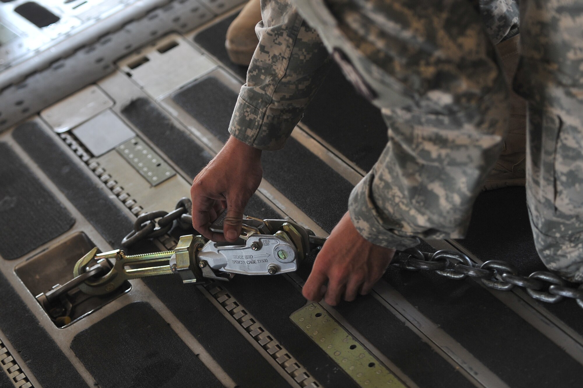 ALTUS AIR FORCE BASE, Okla. – A U.S. Army Soldier from the 1-14th Field Artillery Regiment out of Fort Sill, Okla., secures a M142 High Mobility Artillery Rocket Systems vehicle onto a U.S. Air Force C-17 Globemaster III cargo aircraft during a joint emergency deployment readiness exercise between the 58th Airlift Squadron and 1-14th FAR Aug. 14, 2014. During the training, Soldiers and Airmen practiced loading and offloading HIMARS and various U.S. Army vehicles to prepare for joint operations in a deployed setting. (U.S. Air Force photo by Senior Airman Dillon Davis/Released)