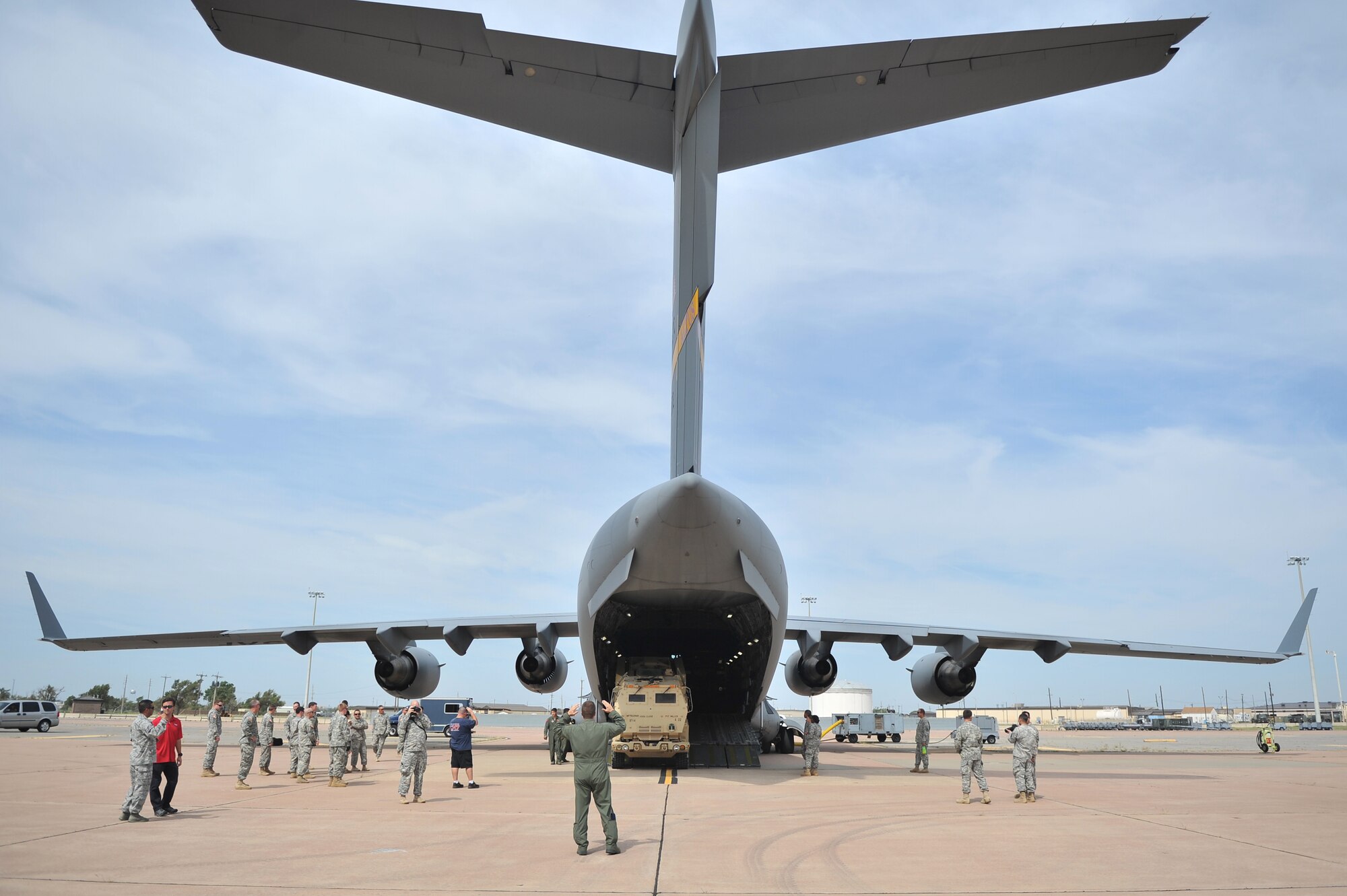 ALTUS AIR FORCE BASE, Okla. – An Airman from the 58th Airlift Squadron guides a U.S. Army cargo truck out of a U.S. Air Force C-17 Globemaster III cargo aircraft during a joint emergency deployment readiness exercise between the 58th and U.S. Army 1-14th Field Artillery Regiment from Fort Sill, Okla. Aug. 14, 2014. The Soldiers and Airmen practiced loading M142 High Mobility Artillery Rocket Systems and other accompanying military equipment to prepare the units for combat operations. (U.S. Air Force photo by Senior Airman Dillon Davis/Released)