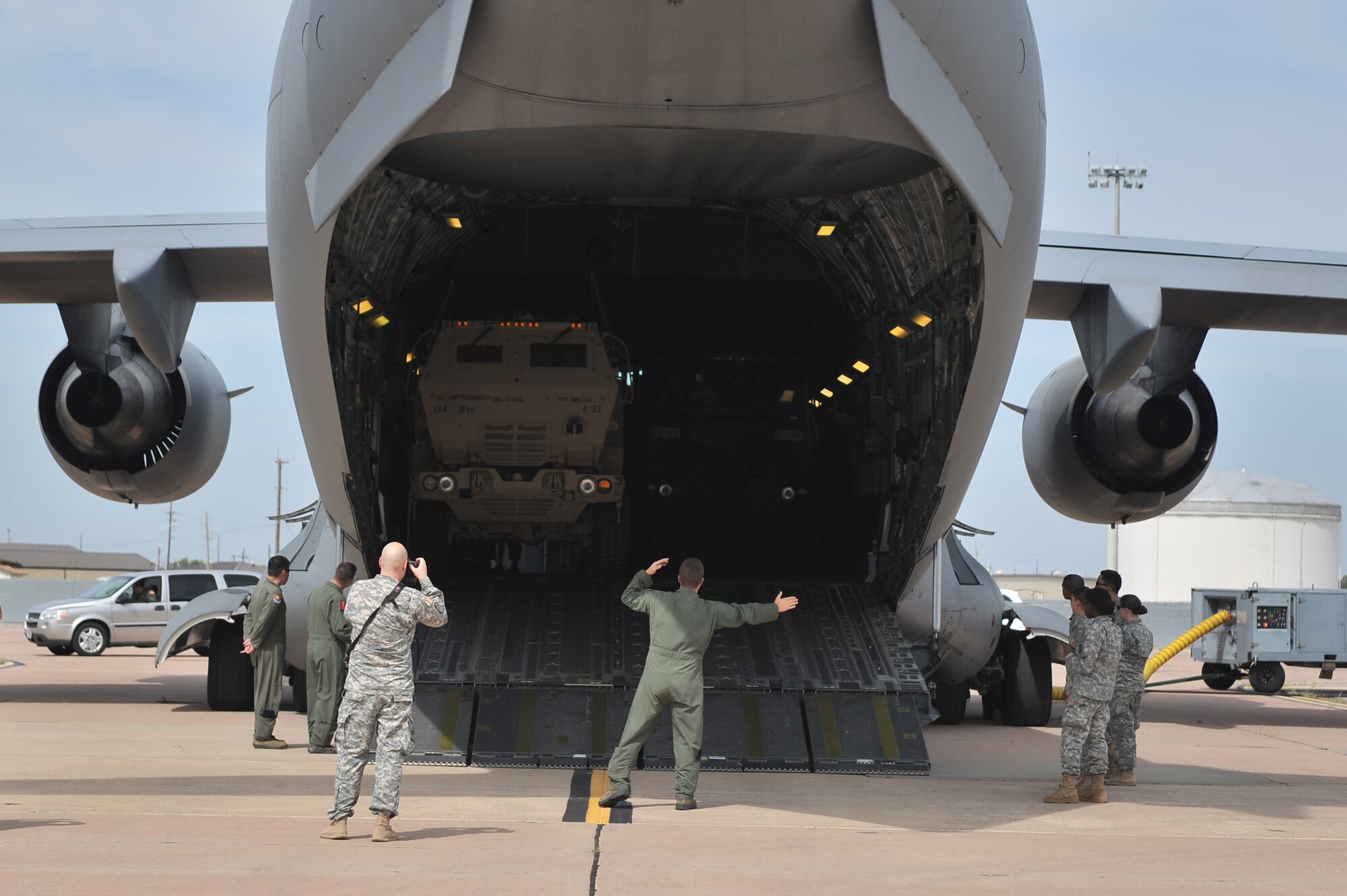 ALTUS AIR FORCE BASE, Okla. – An Airman from the 58th Airlift Squadron guides a U.S. Army cargo truck out of a U.S. Air Force C-17 Globemaster III cargo aircraft during a joint emergency deployment readiness exercise between the 58th and U.S. Army 1-14th Field Artillery Regiment from Fort Sill, Okla. Aug. 14, 2014. The Soldiers and Airmen practiced loading M142 High Mobility Artillery Rocket Systems and other accompanying military equipment to prepare the units for combat operations. (U.S. Air Force photo by Senior Airman Dillon Davis/Released)
