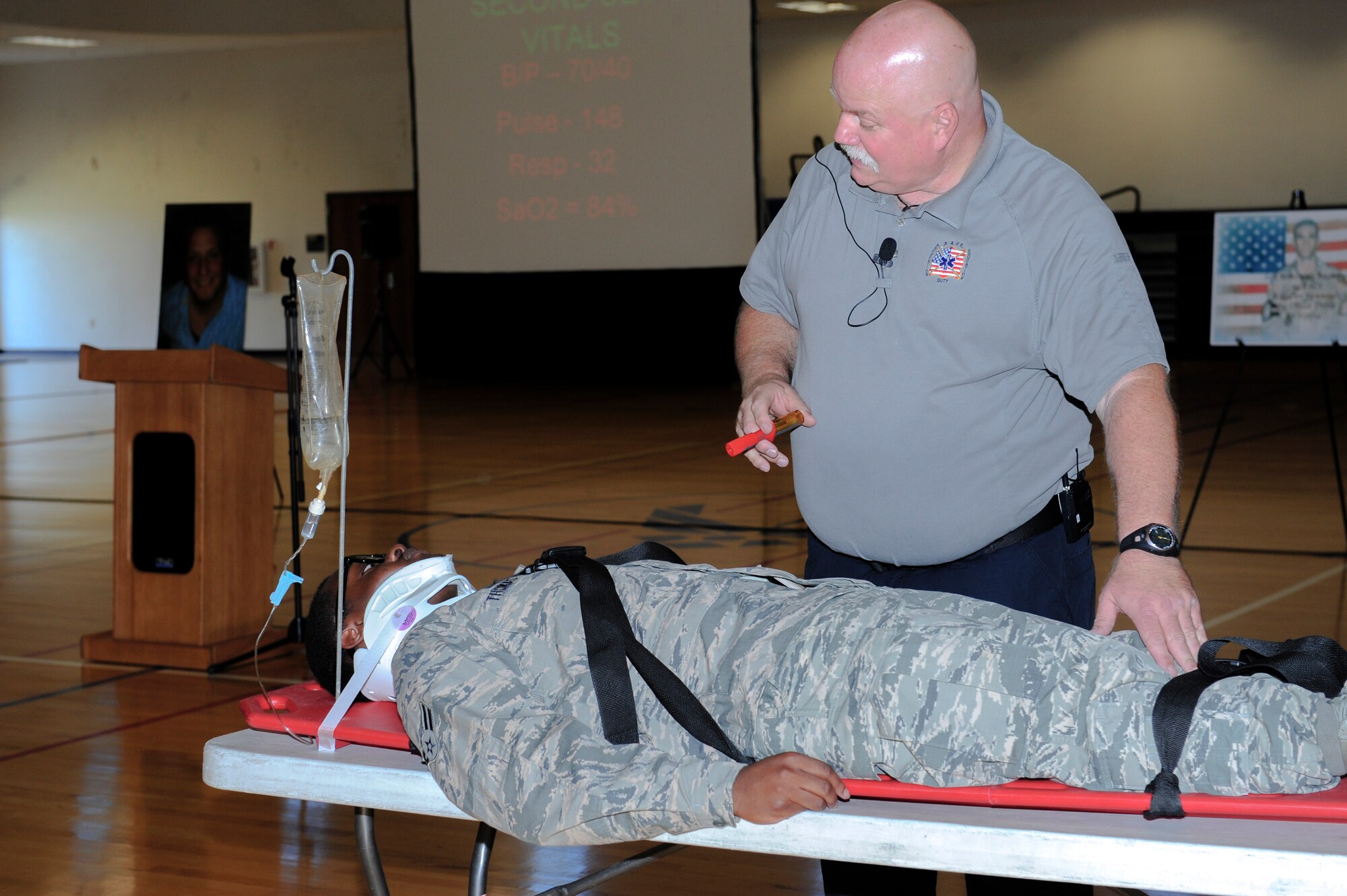 Airman 1st Class Nicholas Thomas, 2nd Space Warning Squadron, assists Greg McCarty, Tampa Fire Rescue paramedic, with the Street Smart presentation during the Team Buckley Safety Day Aug. 12, 2014, at the base fitness center on Buckley Air Force Base, Colo. Street Smart showcased the events that transpire after making a bad decision and getting behind the wheel of a car. (U.S. Air Force photo by Airman 1st Class Samantha Saulsbury/Released)