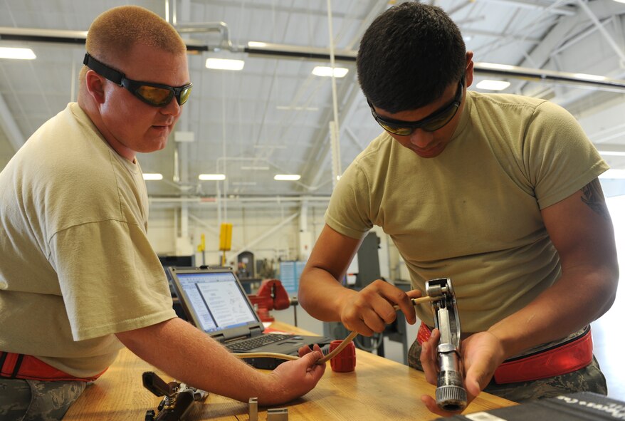 Senior Airman Michael Gaston, 22nd Maintenance Squadron aircraft structural maintenance journeyman shows Airman Ramon Maciel, 22nd MXS aircraft structural maintenance apprentice, how to reflare a fueldrain line, August 15, 2014, at McConnell Air Force Base, Kan. Aircraft structural maintenance Airmen repair hydro lines and damaged panels, and paint KC-135 Stratotankers. (U.S. Air Force photo/Airman 1st Class David Bernal Del Agua)